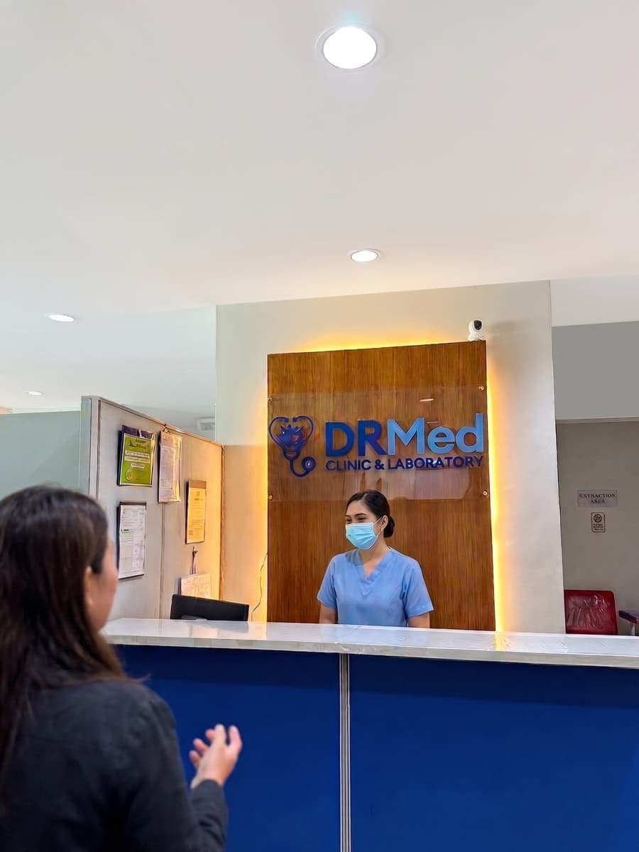 DRMed Clinic and Laboratory reception counter with staff greeting a patient